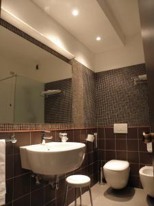 un bagno con lavandino, water e specchio di Hotel Ghironi a La Spezia