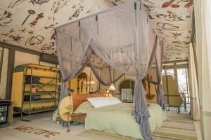 a bedroom with a bed with a canopy at Saseka Tented Camp in Hoedspruit