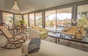 a living room with chairs and a table and windows at Saseka Tented Camp in Hoedspruit