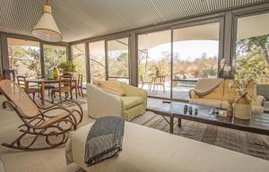 a living room with chairs and a table and windows at Saseka Tented Camp in Hoedspruit +76 photos