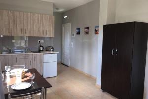 a kitchen with a table and a black cabinet at Rodanthy II in Katelios +3 photos