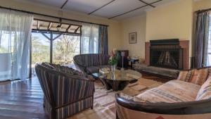 a living room filled with furniture and a fireplace at Sarova Lion Hill Game Lodge in Nakuru