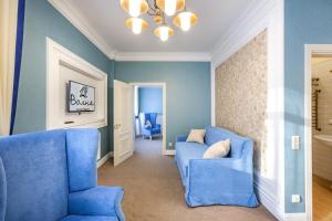 una sala de estar azul con sillas azules y una lámpara de araña en Гостиница Волна, en Tyumen