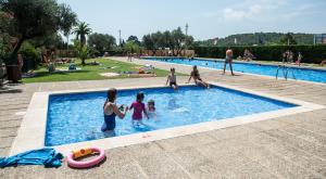 Camping Relax Ge في Montrás: مجموعة من الناس يلعبون في حمام السباحة