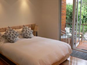 1 dormitorio con 1 cama y balcón en the boatshed waterfront b&b en Port Fairy