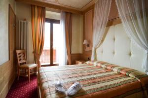 Hotel Cristallo tesisinde bir odada yatak veya yataklar