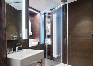a bathroom with a sink and a glass shower at Axel Hotel San Sebastián - Adults Only in Donostia-San Sebastián