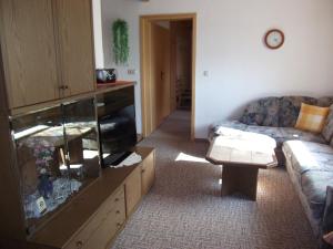 a living room with a fish tank and a couch at Ferienwohnung Erzgebirge - Pobershau - mit schönem Ausblick, ruhige, beste Lage in Pobershau