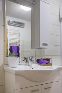 a kitchen sink with a mirror and a purple towel at Luxury villa Luck in Imotski, private pool in Imotski