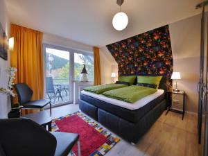 a bedroom with a bed and a large window at Ferienwohnung M am Kurpark**** inkl. MeineCard+ in Willingen