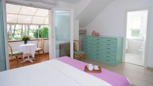 - une chambre avec un grand lit et une table avec une salle à manger dans l'établissement Villa Scultura Seaview, à Lignano Sabbiadoro