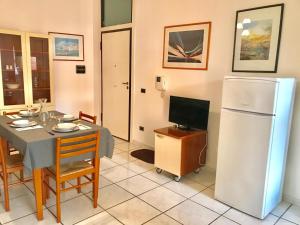 a dining room with a table and a refrigerator at Trilocale Lalla sul mare in Gallipoli