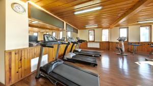 a gym with several treadmills and a row of exercise bikes at Balneo & SPA Hotel Aura in Velingrad