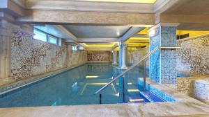 una piscina en un edificio con una pared de azulejos en Balneo & SPA Hotel Aura, en Velingrad