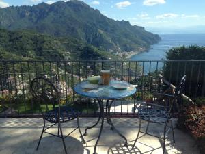 una mesa en un balcón con vistas al océano en La Casa di Vania, en Ravello