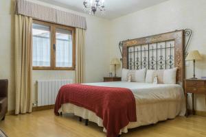 sypialnia z dużym łóżkiem i czerwonym kocem w obiekcie Casa Rural El Capricho w mieście Otero de Herreros