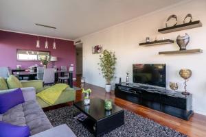 uma sala de estar com um sofá e uma televisão em Monumental Residence apartment with pool by HR Madeira no Funchal
