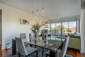 uma sala de jantar com uma mesa de vidro e cadeiras em Monumental Residence apartment with pool by HR Madeira no Funchal