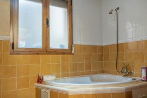 wanna w łazience z oknem w obiekcie Casa Rural El Capricho w mieście Otero de Herreros +25 zdjęć
