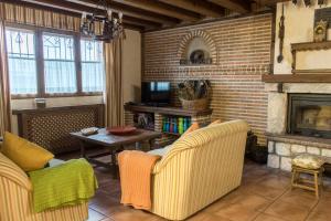 salon z 2 krzesłami i kominkiem w obiekcie Casa Rural El Capricho w mieście Otero de Herreros