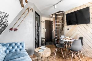 a living room with a blue couch and a table at Apartamenty Tatra Race in Zakopane