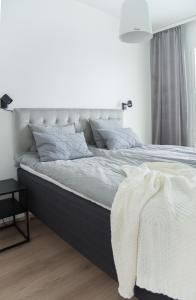 a bedroom with a large bed with white sheets and pillows at Lapland Arctic Apartments in Rovaniemi