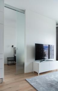 a living room with a tv on a white wall at Lapland Arctic Apartments in Rovaniemi