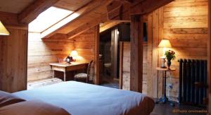 sypialnia z łóżkiem i biurkiem w pokoju w obiekcie Chambres d'Hôtes Le Barna w mieście Clusaz