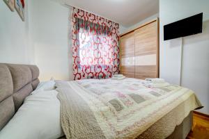 a bedroom with a bed with a red curtain at Apartman 008 in Zlatibor