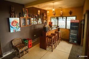 a restaurant with a bar with stools and a counter at Busua Inn in Busua
