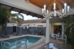 a house with a swimming pool and a chandelier at A Smart Stay Apartments in Somerset West