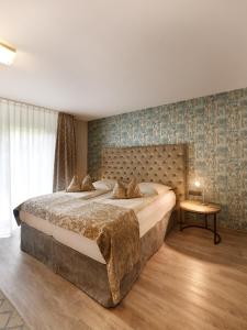 een slaapkamer met een groot bed en een tafel bij Art Hotel Superior in Aken