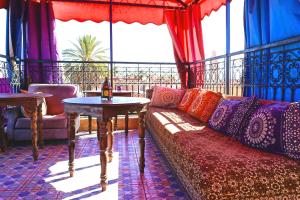 sala de estar con sofá y mesa en Riad Jennah Rouge, en Marrakech