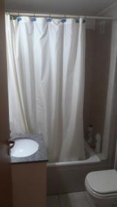 y baño con cortina de ducha blanca y aseo. en COSTANERA en Rosario