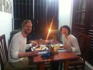 un hombre y una mujer sentados en una mesa comiendo comida en Witherspoon Lodge en Kandy