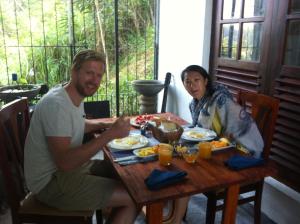 un hombre y una mujer sentados en una mesa comiendo comida en Witherspoon Lodge en Kandy