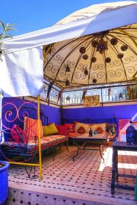 Riad Layla Rouge في مراكش: غرفة معيشة مع أريكة ومظلة