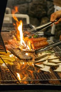 Eine Person kocht Essen auf einem Grill in der Unterkunft Sun and Moon Resort in Seogwipo