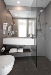 ein Bad mit einer Badewanne, einem WC und einer Dusche in der Unterkunft Go Hotel City in Kopenhagen