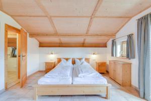 una camera con letto e soffitto in legno di Jaudenhof - Apartment Schönbergalm a Lenggries