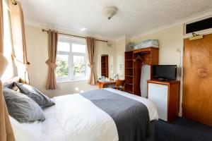 a hotel room with a bed and a television at Blue Boar Inn in Norwich