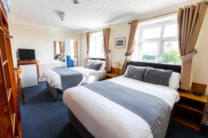 a hotel room with two beds and a television at Blue Boar Inn in Norwich