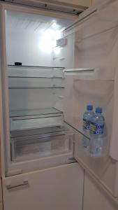 an open refrigerator with two bottles of water in it at Apartament Fibra Essenza in Rybnik