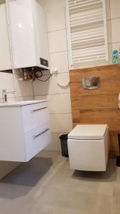 a white bathroom with a toilet and a sink at Apartament Fibra Essenza in Rybnik +18 photos