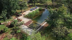 una vista aérea de una piscina de agua con sillas azules en Dudhsagar Plantation, en Cormonem