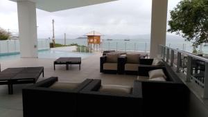 a patio with furniture and a view of the ocean at Beira-mar praia da cachoeira Florianópolis in Florianópolis