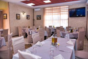 a dining room with white tables and white chairs at Balneo and SPA Complex MINERAL YAGODA in Yagoda
