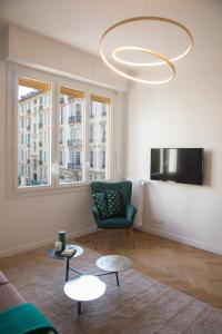 ein Wohnzimmer mit einem Sofa, 2 Tischen und einem Kronleuchter in der Unterkunft Beautiful apartment in the heart of Nice in Nizza