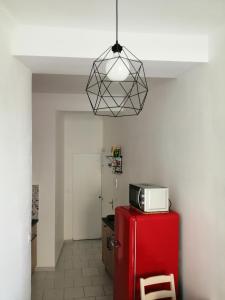 a microwave on top of a red refrigerator in a kitchen at LE PETIT VENTOUX VILLAGE in Malaucène