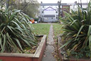 a path in a yard with plants and a house at Park City Rooms in Manchester